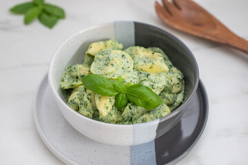 Italian Tortellini with spinach and basil on a table