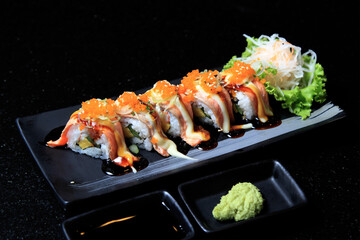 Sushi with salmon on a black Asian plate. A restaurant. horizontal orientation.