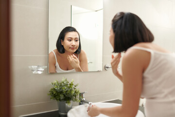 Fototapeta premium Closeup of beautiful young woman washing face in bathroom