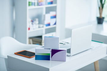 Laptop, tablet and packages with medicines on the table