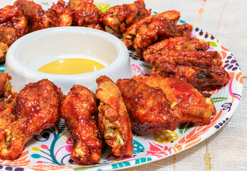 Homemade BBQ wings served in a colorful platter.