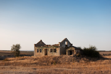 Landscape of abandoned house in dry field.