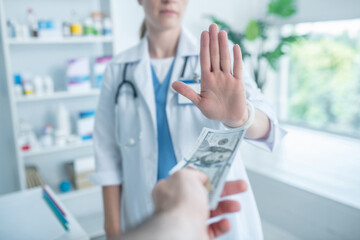 Person in a lab coat refusing to take money