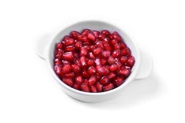 Pomegranate in white bowl on white background