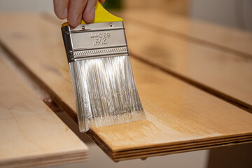 Varnishing a wooden surface with a synthetic brush