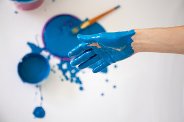 female hand stained with blue paint
