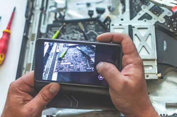 a man repairs a computer, solders a board, repairs electronics and modern technologies