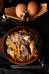 Stir-fried soy sauce, green tea yakisoba noodles with pork. Dark tone.
