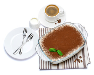 Traditional Italian Tiramisu dessert in glass baking dish and cup of fresh espresso coffee isolated on white background with clipping path