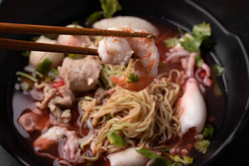 Holding shrimp Yentafo in black bowl