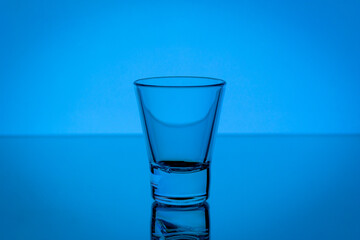 Empty glass against neon light background on bar counter, nightlife, concept. High quality photo