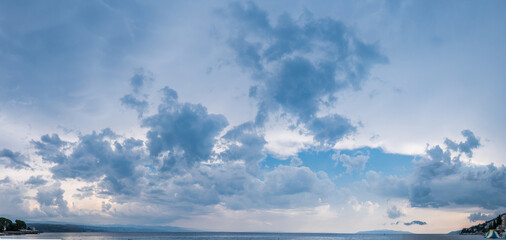 Obraz premium Calm sea and cloudy sky pierced with sun rays. Beautiful nature background.