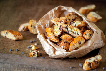 Delicious homemade cantucci biscuits or Italian biscotti with chocolate drops on dark rustic wooden...