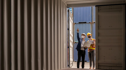 Inspector talking with female dock worker used laptop checking cargo freight. Businessman consult with engineer about transport container in shipping yard. logistics and transportation concept.