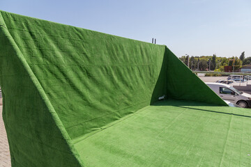 A small stage covered with green carpet.