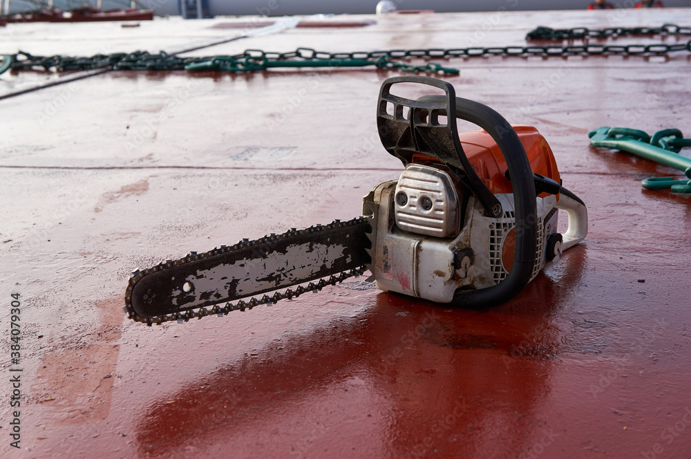 Wall mural chain saw laying on deck of ship