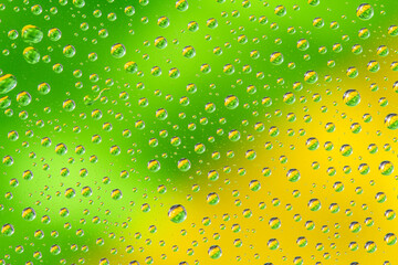 Water drops on green yellow background. Top view. Closeup.