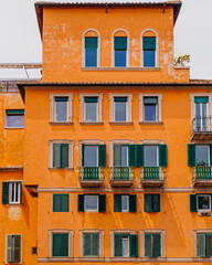 Fototapeta premium orange walls house front with green windows, Rome Italy