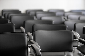 Fototapeta premium Empty black chairs stand in conference hall