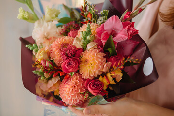 woman holding a gift bouquet of dahlias gladiolus spray rose
