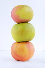 Three apples stacked against white background