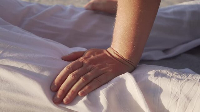 Close up young female making thai yoga massage on a wooden floor at sunrise