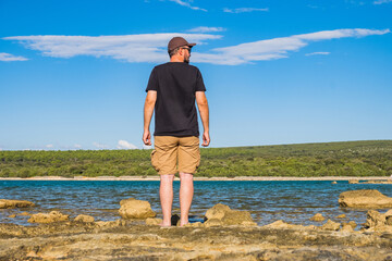 Man in short cargo pants observing the sea surface, Losinj island, Croatia