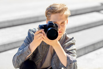 leisure, technology and people concept - young man or teenage boy with digital camera photographing in city © Syda Productions