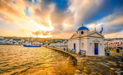 Picturesque view of seafront with greek church of Mykonos at sunset