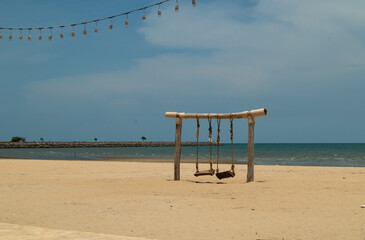 Empty swings on the beach.