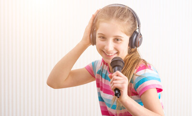 Girl in headphones broadcasting for blog holding microphone in left hand