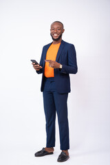 african businessman using his phone and credit card smiling, standing against a white background