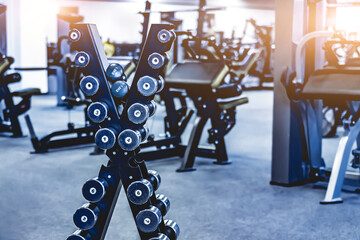 Fototapeta na wymiar rows with a set of dumbbells and exercise equipment in modern gym