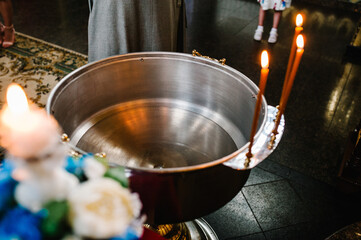 The sacrament of baptism. Attributes of an Orthodox priest for baptism. Baptism in the font. Child...