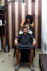 Fototapeta na wymiar dye hair of a man in bathroom sink in hairdresser salon, barbershop