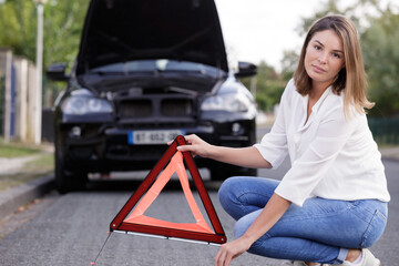 woman holding a red triangle on the road