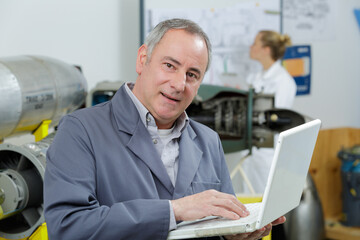 Naklejka na ściany i meble mature male technician using laptop