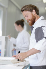 Fototapeta premium bearded decorator applying wallpaper paste