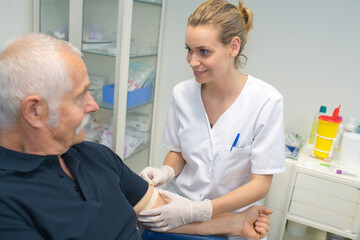 Fototapeta premium nurse releasing tourniquet from patients arm