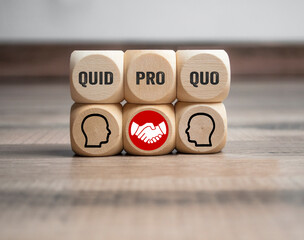 Cubes and dice with business message quid pro quo on wooden background
