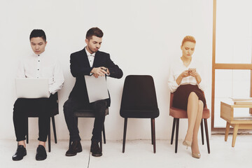 A man in a suit looks at his watch while waiting. 