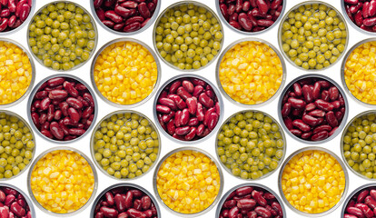 Seamless background of flat lay opened tin cans with green peas, sweet corn and kidney beans isolated on white background. Clipping path added