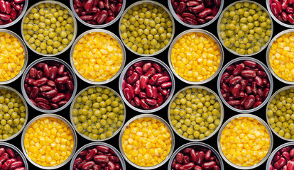 Seamless background of flat lay opened tin cans with green peas, sweet corn and kidney beans isolated on black background. Clipping path added