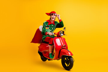 Portrait of his he nice attractive cheerful cheery glad funny guy elf riding moped bringing fast...