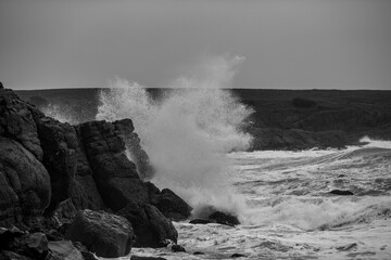 Dark moody autumn seascape landscape, stormy Black Sea, Bulgaria. Splashing sea waves and harsh cold windy weather. Black and white impression