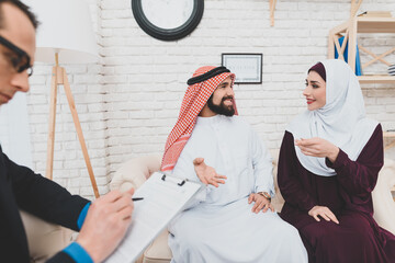 Muslim woman with arab man sitting in office. 