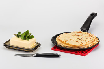 very tasty pancakes on a hot frying pan with chilled butter