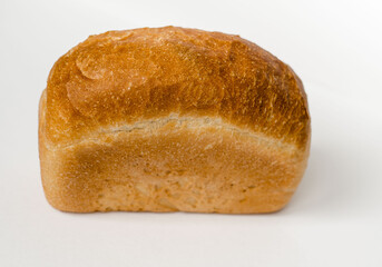 A loaf of bread on a light gray background. Bakery product. The products of the first necessity.