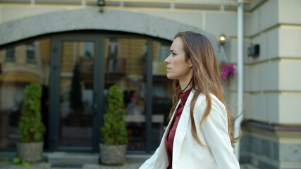 Fototapeta premium Thoughtful business woman walking outdoors. Serious businesswoman