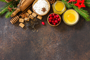 Fototapeta na wymiar Baking winter. Ingredients for Christmas baking - cocoa, cranberries, spices, nuts, flour and eggs on a rustic wooden table. Top view flat lay background. Copy space.